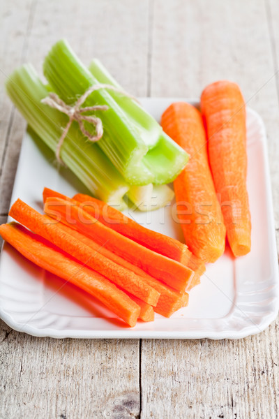 bundle of fresh green celery stems and carrot in plate Stock photo © marylooo