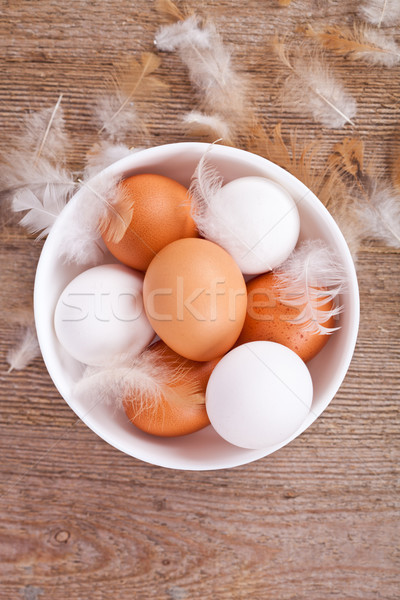 eggs and feathers on wooden table Stock photo © marylooo