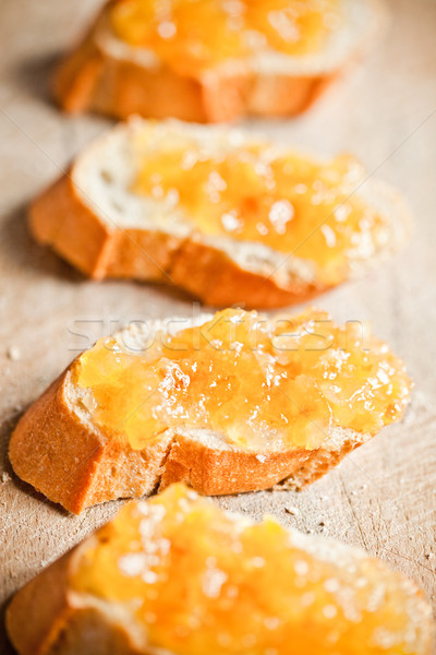 pieces of baguette with orange marmalade closeup on wooden board Stock photo © marylooo
