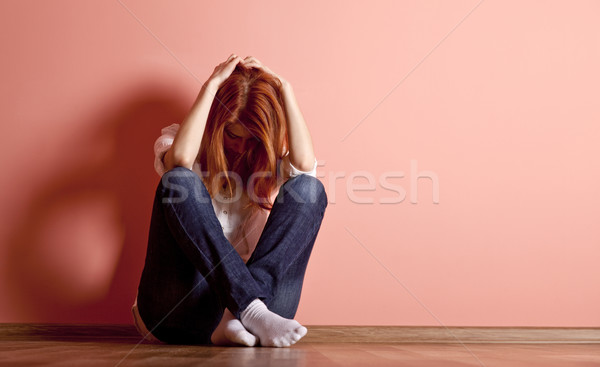 Sad teen girl at floor near wall.  Stock photo © Massonforstock