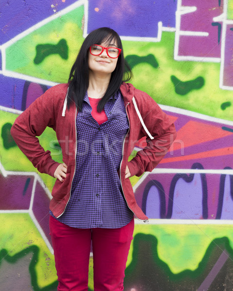 Stock photo: Style teen girl standing near graffiti wall.