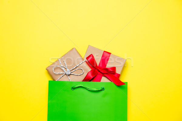 cute gifts in beautiful green shopping bag on wonderful yellow b Stock photo © Massonforstock