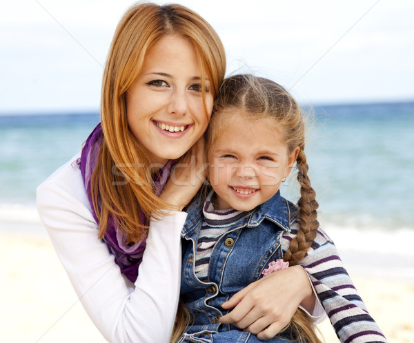 Two sisters 5 and 22 years old at the beach in sunny autumn day. Stock photo © Massonforstock