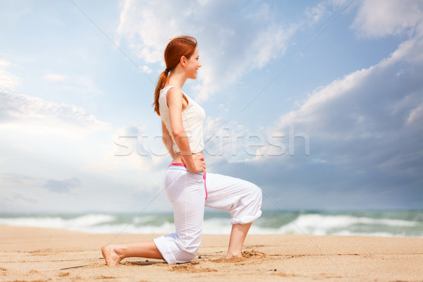 athletic woman performing a kick in an sand beach Stock photo © Massonforstock