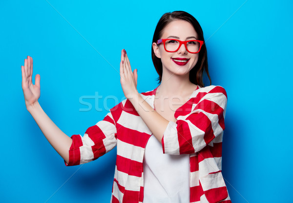 portrait of the beautiful young smiling woman on the blue backgr Stock photo © Massonforstock