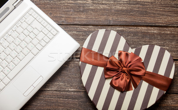 photo of cute wrapped gift and laptop on the wonderful brown woo Stock photo © Massonforstock