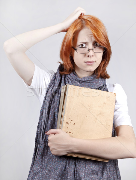 Young doubting fashion girl in glasses with old book Stock photo © Massonforstock