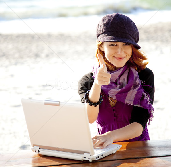 Portrait of red-haired girl with laptop at beach. Stock photo © Massonforstock