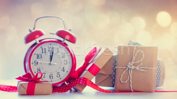 Stock photo: big alarm clock, red ribbon and beautiful gifts on the fairy lig