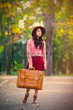 Beautiful girl with suitcase at autumn park.  Stock photo © Massonforstock