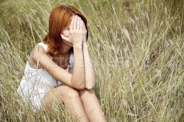 Sad red-haired girl at grass. Stock photo © Massonforstock