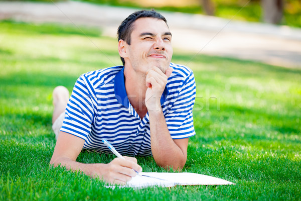 photo of handsome man lying on the grass and thinking about some Stock photo © Massonforstock