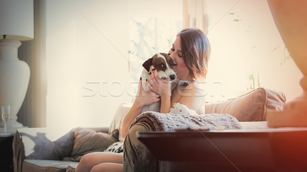 Piękna młoda kobieta posiedzenia sofa psa Zdjęcia stock © Massonforstock
