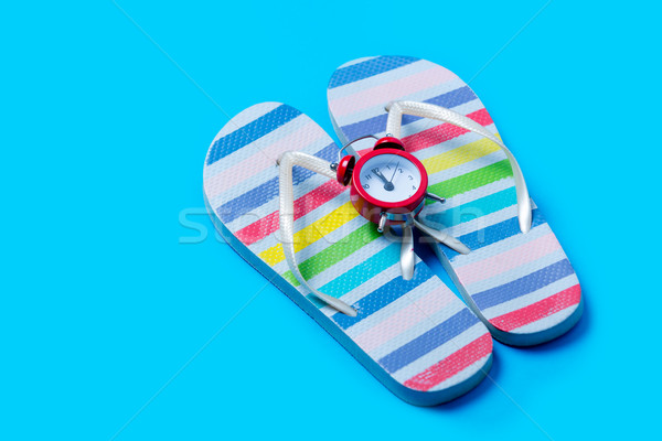 Stock photo: colorful sandals and cute small alarm clock on the wonderful blu