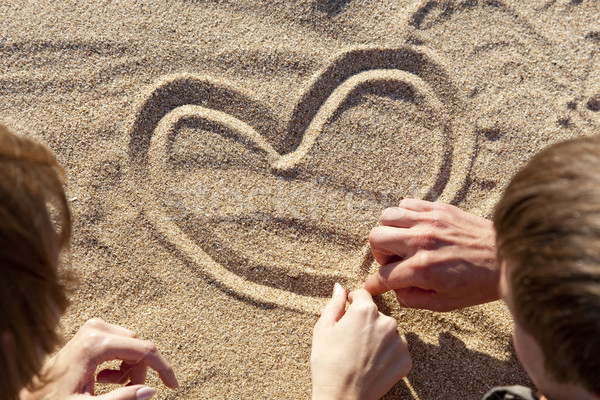 People drawing heart at sand Stock photo © Massonforstock