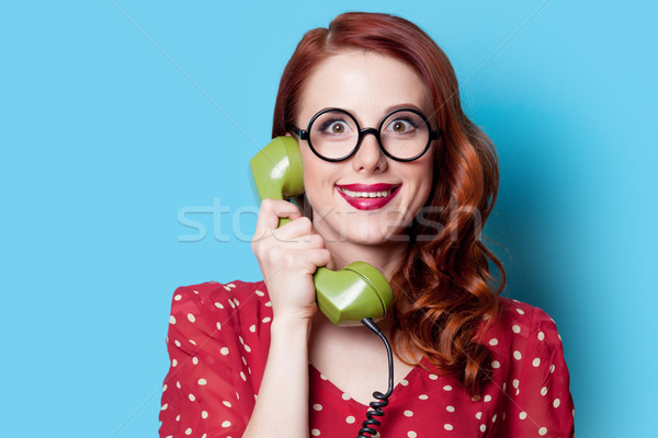 Stock photo: girl in red dress with green dial phone