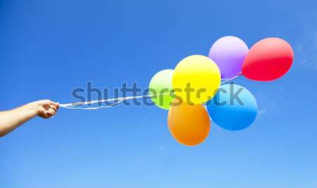 Redhead girl with colour balloons at blue sky background.  Stock photo © Massonforstock