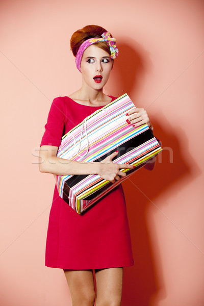 Style redhead girl with shopping box at pink background. Stock photo © Massonforstock