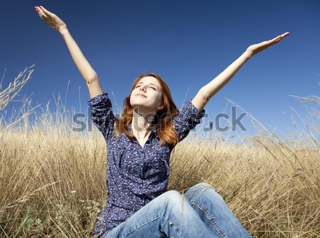 Stock photo: Portrait of happy red-haired girl on autumn grass.