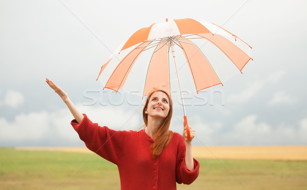 Redhead girl with umbrella at meadow Stock photo © Massonforstock