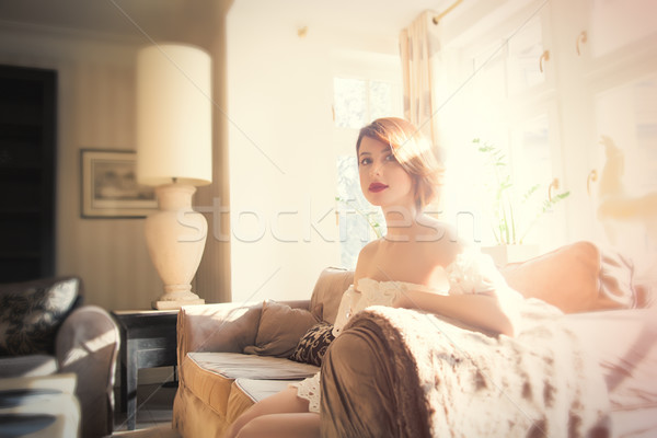 beautiful young woman sitting on the sofa in the light luxury ro Stock photo © Massonforstock