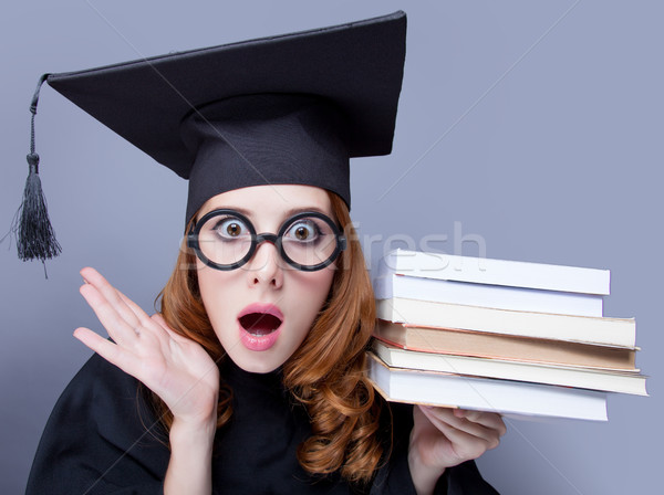 photo of beautiful young alumnus with pile of books on the wonde Stock photo © Massonforstock
