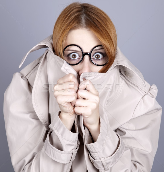 Stock photo: Hiding red-haired girl in glasses and cloak.