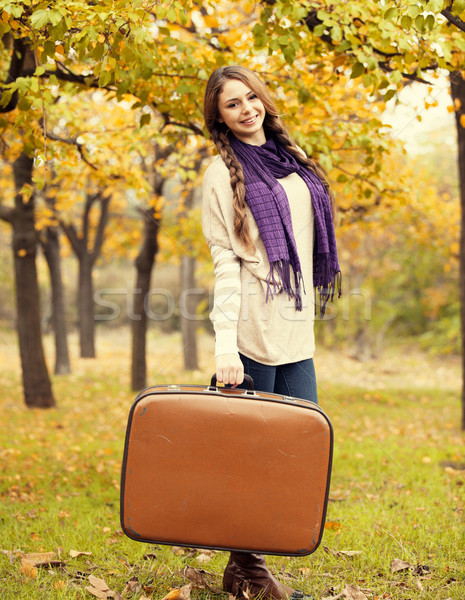 Beautiful girl with suitcase at autumn park.  Stock photo © Massonforstock