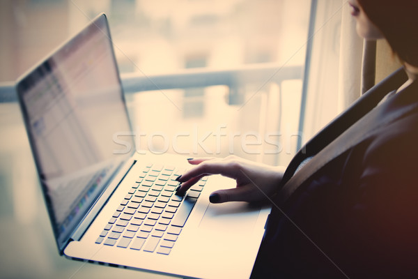 young beautiful woman holding a notebook and typing text near th Stock photo © Massonforstock