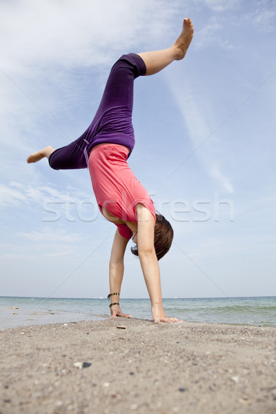 Młoda dziewczyna pokaż akrobatyczny plaży dzieci zdrowia Zdjęcia stock © Massonforstock