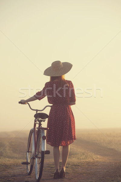 Girl on a bike in the countryside in sunrise time Stock photo © Massonforstock