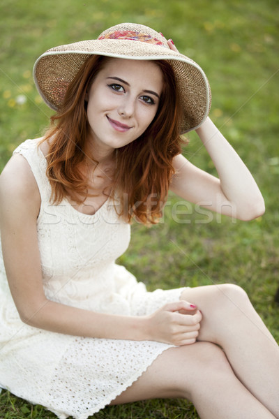 Stock photo: Redhead girl at green grass at village outdoor.