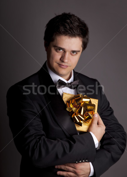 A man holding present box in formal black tux  Stock photo © Massonforstock