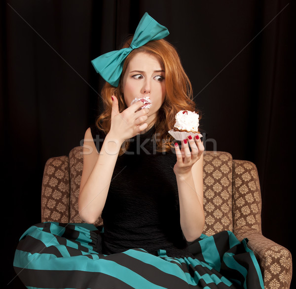 Stock photo: Redhead girl secretly eating cake.