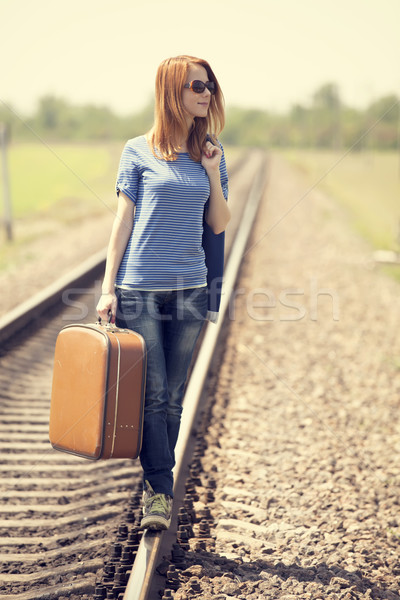 Stock photo: Young fashion girl with suitcase at railways.