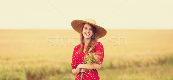 Redhead girl in red dress at wheat field Stock photo © Massonforstock