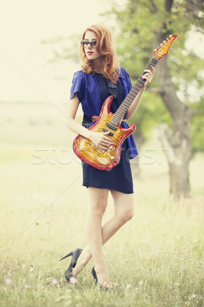 Style redhead girl with guitar at outdoor. Stock photo © Massonforstock