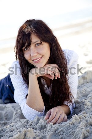 Pretty young woman lying down on beach Stock photo © Massonforstock
