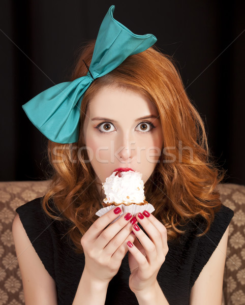 Stock photo: Redhead girl secretly eating cake.