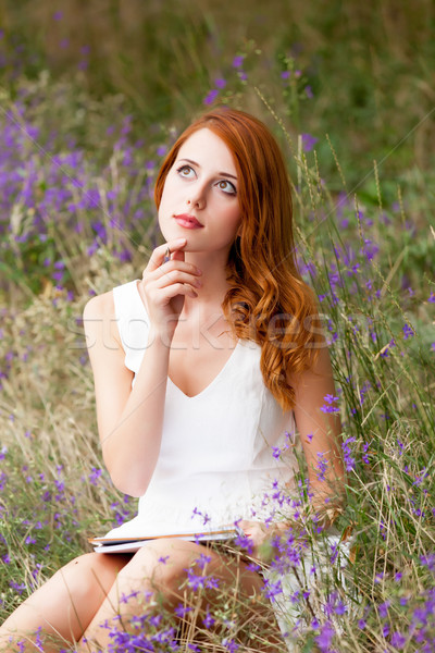 photo of beautiful young woman with copybook sitting on the gras Stock photo © Massonforstock