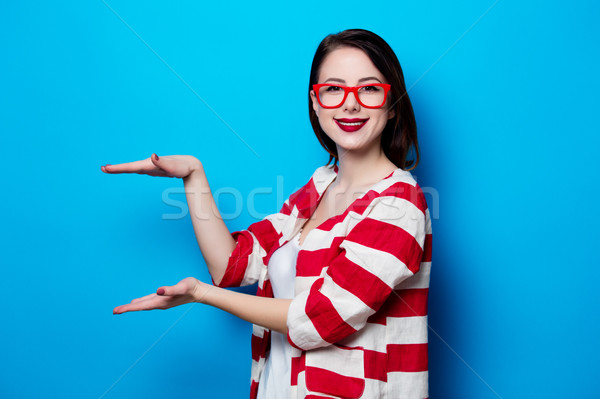 portrait of the beautiful young smiling woman on the blue backgr Stock photo © Massonforstock