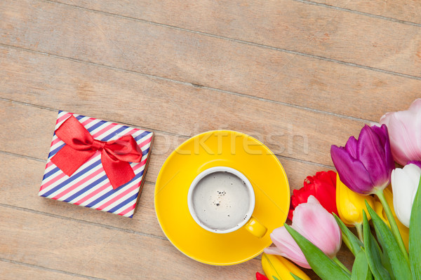 photo of cup of coffee, cute gift and colorful tulips on the won Stock photo © Massonforstock