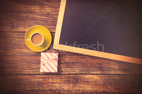 Cup of coffee near gift and blackboard  Stock photo © Massonforstock