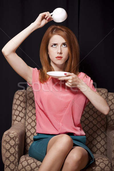 Surprised redhead girl with cup of coffee. 70s Stock photo © Massonforstock