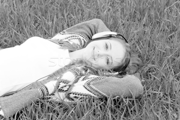 Young fashion girl with headphones lying at grass. Photo in blac Stock photo © Massonforstock