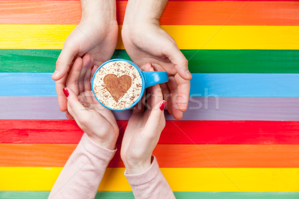 photo of male and female hands holding cup of coffee on the wond Stock photo © Massonforstock