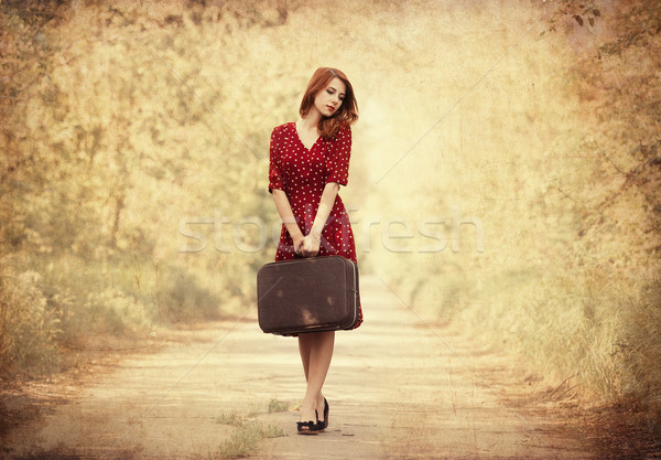 Redhead girl with suitcase at tree's alley. Stock photo © Massonforstock