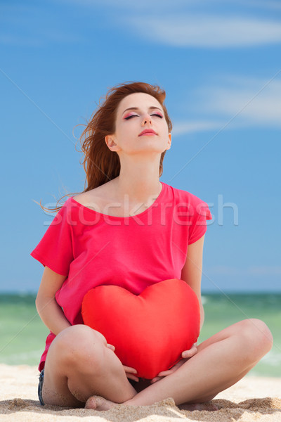 Redhead teen girl with heart shape on the beach Stock photo © Massonforstock