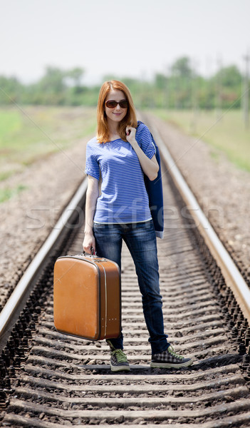 Young fashion girl with suitcase at railways. Stock photo © Massonforstock