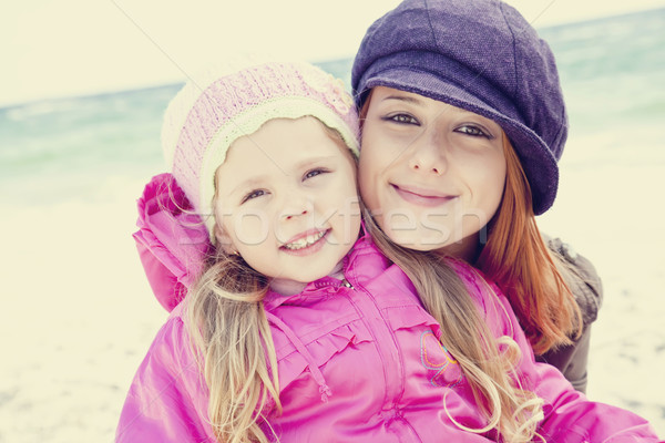 Two sisters 4 and 21 years old at the beach in sunny autumn day. Stock photo © Massonforstock